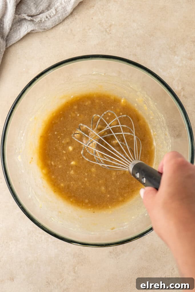 Whisking together the wet ingredients in a bowl.