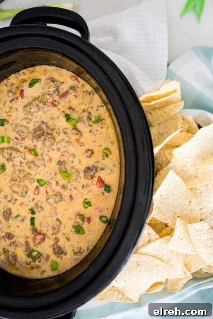 Slow Cooker Queso with Beef and Sausage 2 slow cooker with velveeta spicy cheese dip with sausage and ground beef and tortilla chips