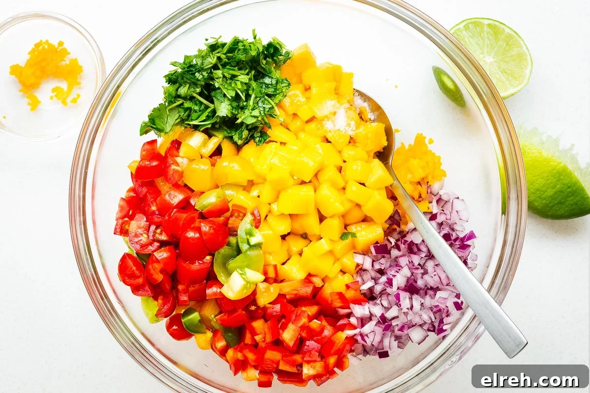 Diced ingredients for fresh mango habanero salsa in a glass bowl.