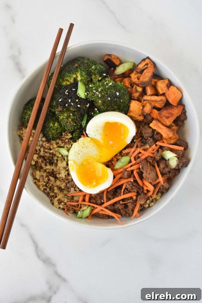 Ground Beef Stir-Fry Recipe with Vegetables 6 A beef stir fry bowl with a jammy egg on top on a white marble table