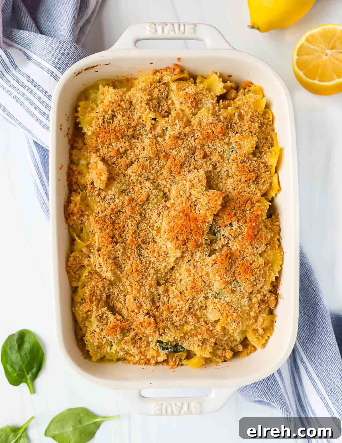A white baking dish filled with pasta that is topped with toasted bread crumbs.