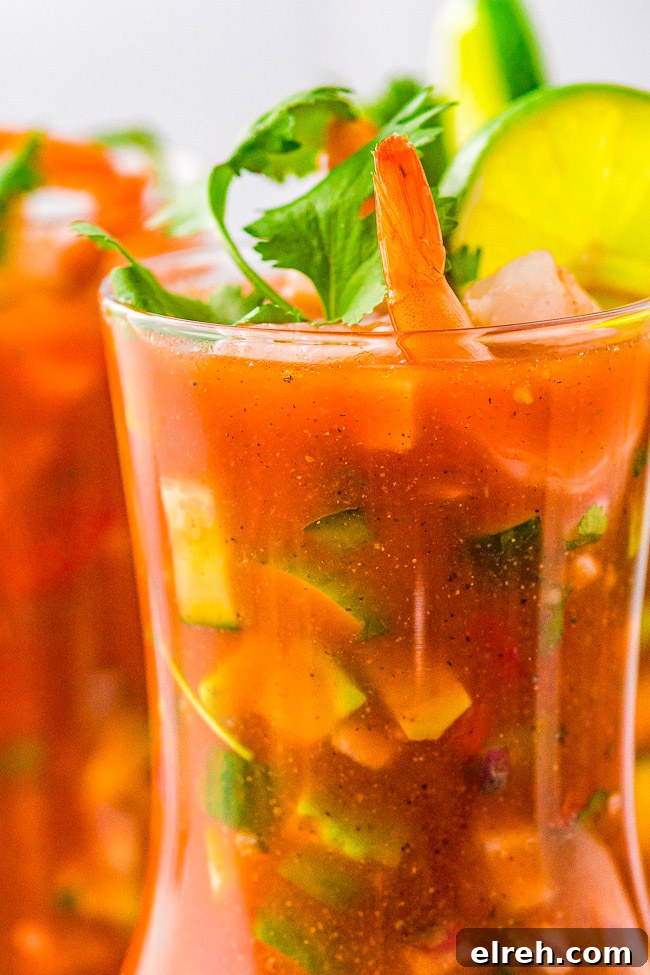 Authentic Mexican Shrimp Cocktail Recipe 13 A vibrant shrimp cocktail adorned with a sprig of cilantro and a lime wedge.