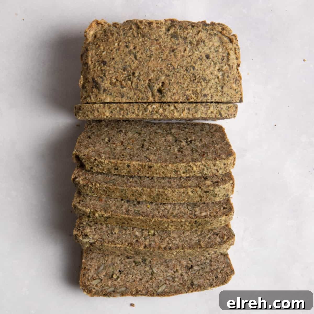 Gluten-Free Seeded Loaf Recipe with Flax, Sunflower and Chia 2 Overhead shot of sliced seeded bread on white surface.