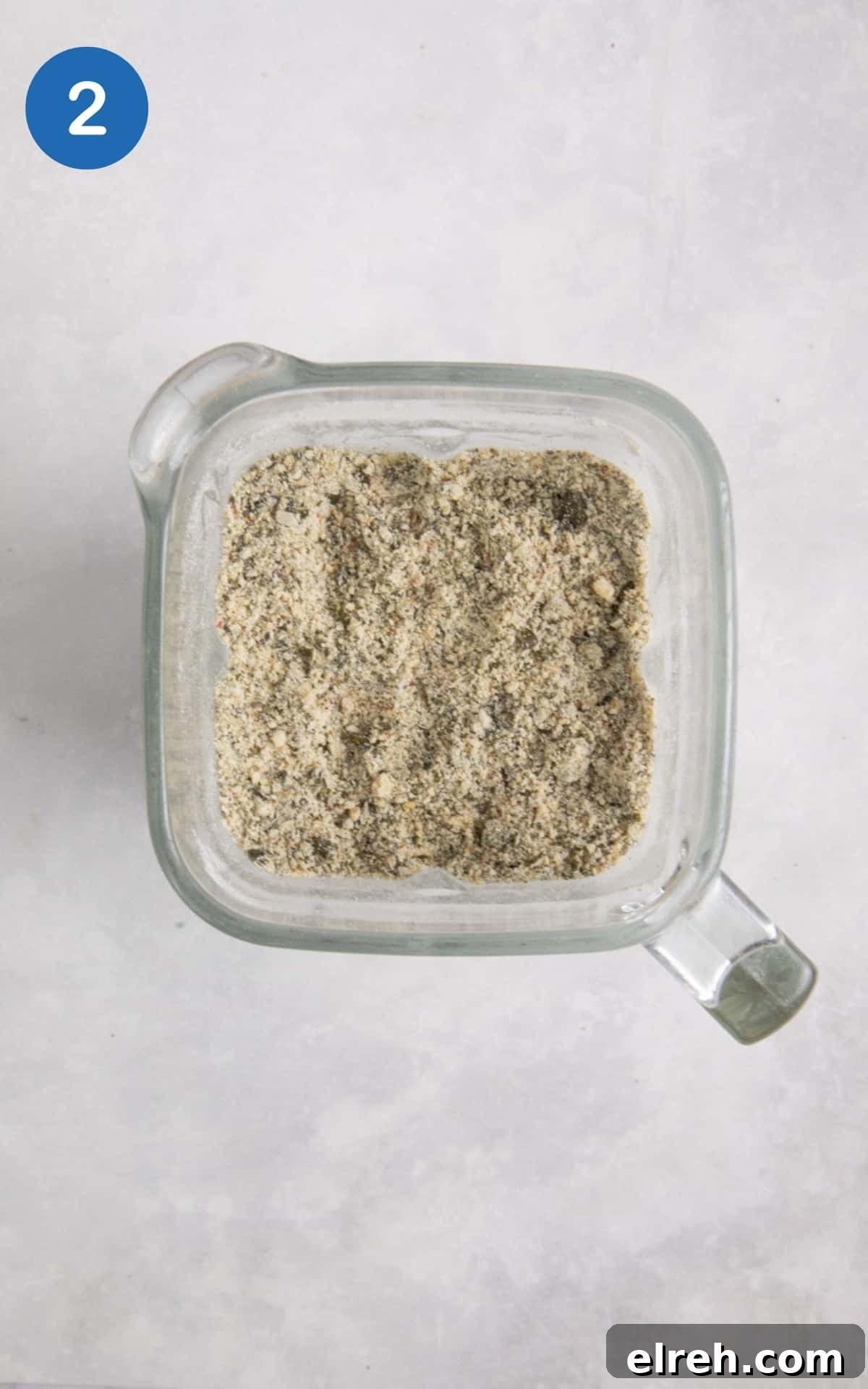 Gluten-Free Seeded Loaf Recipe with Flax, Sunflower and Chia 5 blended seeds with flour in food processor on white surface.