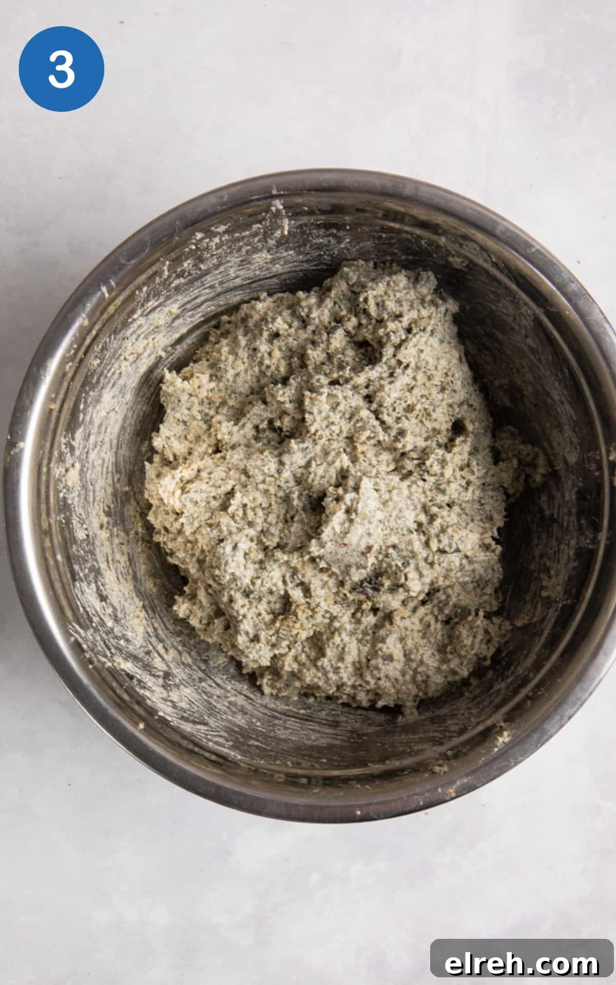 Gluten-Free Seeded Loaf Recipe with Flax, Sunflower and Chia 6 bread dough in silver mixing bowl on white surface.