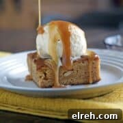 Caramel blondie brownie with a scoop of ice cream and caramel drizzled on top on a white plate