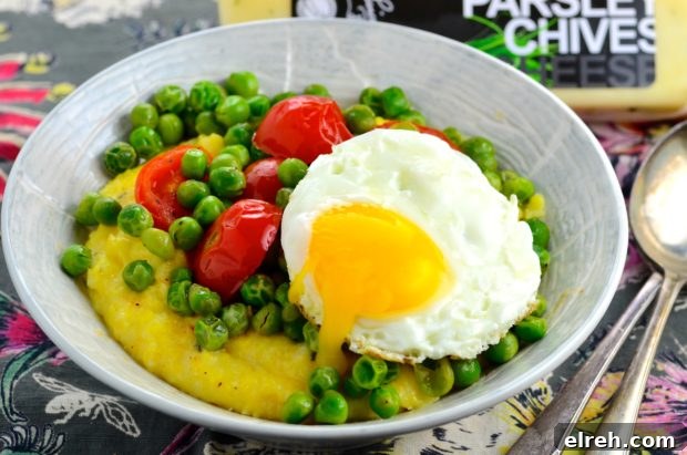 Close-up of peas and grits with herbs and tomatoes.
