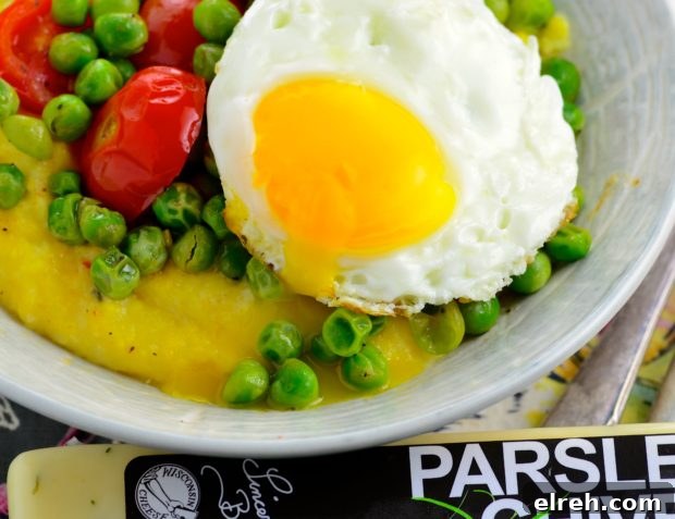 Final plating of peas, cheese and grits with an egg on top.