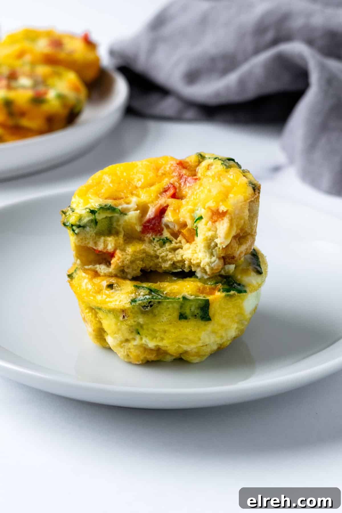 Two Egg bites stacked with one missing a bite.