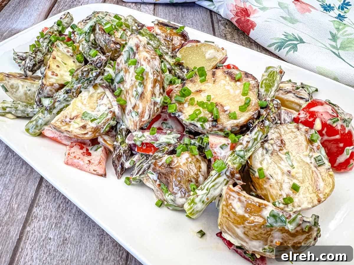 Close-up shot of Grilled Asparagus and Potato Salad on a white plate.