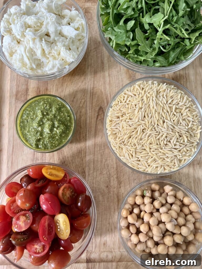 All ingredients to make caprese pasta salad in glass bowls.