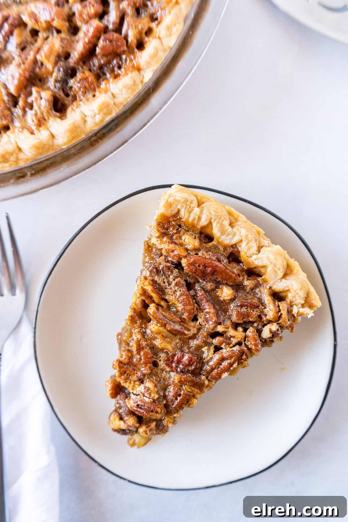 Old Fashioned Pecan Pie Recipe 5 A slice of pecan pie on a plate, showcasing a golden crust and toasted pecans.