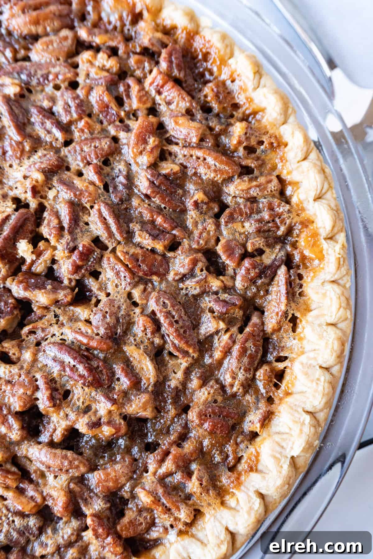 Old Fashioned Pecan Pie Recipe 10 Baked pecan pie in a glass pie dish, showing golden crust and toasted pecans.
