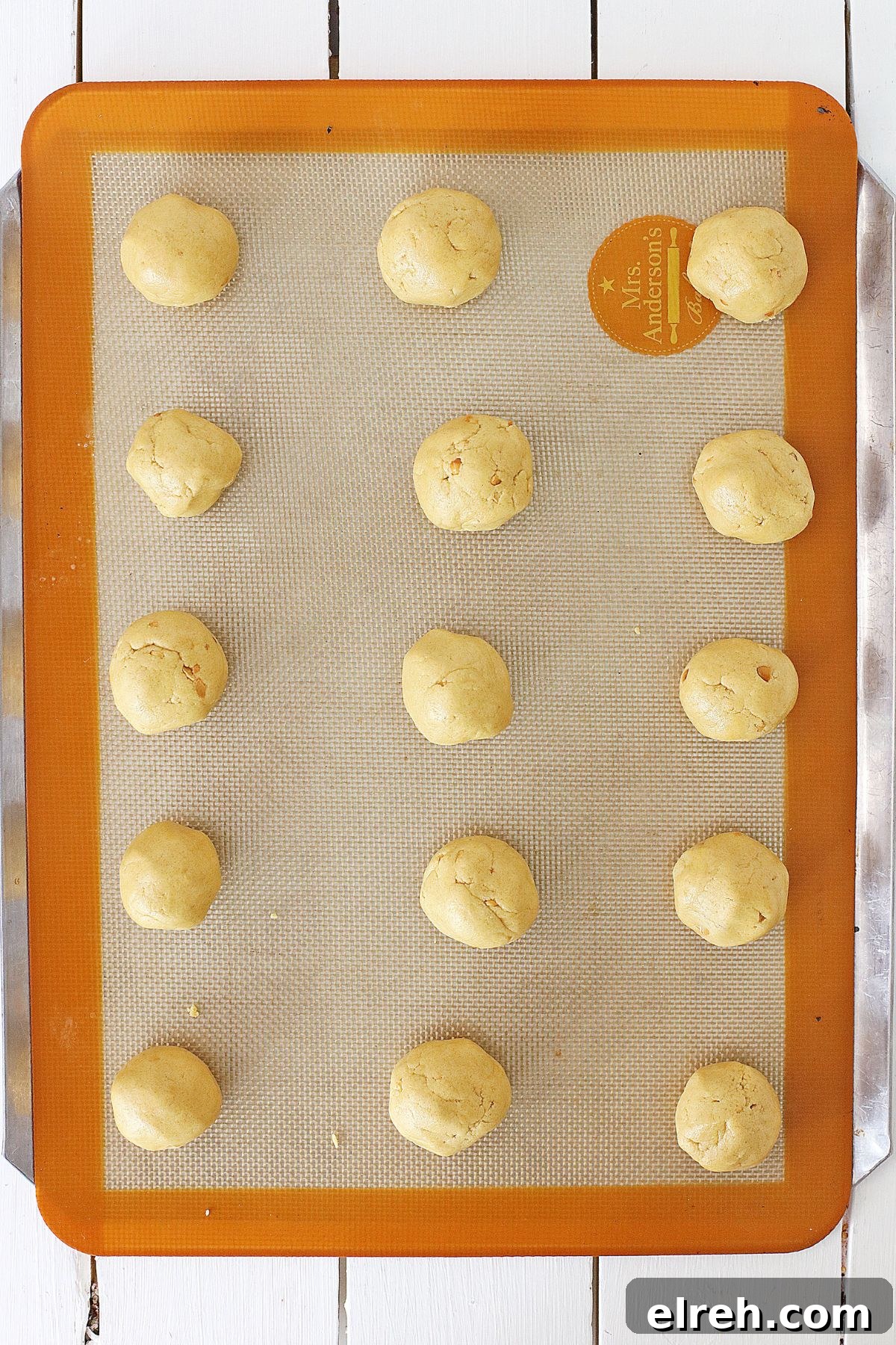 Muddy Buddy Cookies: Chocolate Peanut Butter Crunch 5 raw peanut butter cookie dough balls on a silicone mat lined baking sheet.