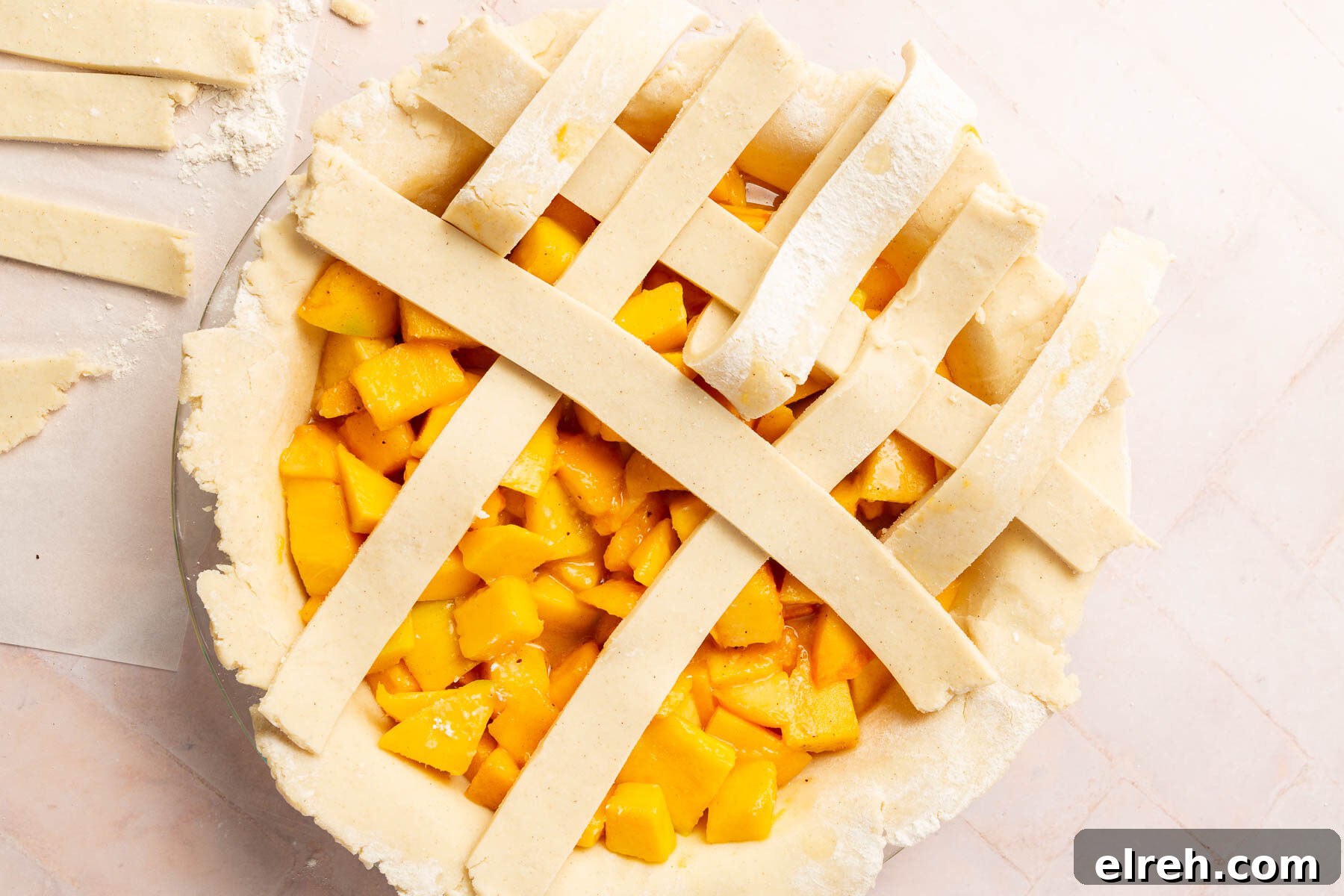 Gluten-Free Peach Mango Pie Recipe 11 A gluten-free lattice pie crust being woven over peach mango pie filling.