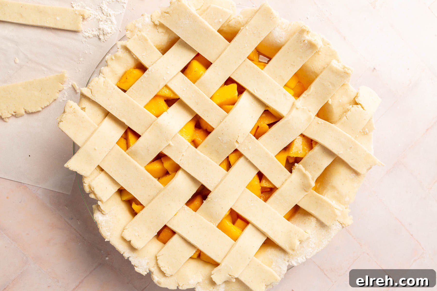 Gluten-Free Peach Mango Pie Recipe 12 An overhead view of an unbaked gluten-free peach mango pie with a lattice crust.