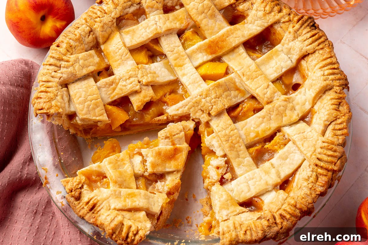Gluten-Free Peach Mango Pie Recipe 15 A gluten-free peach mango pie with a lattice top in a glass pie plate with one slice removed.