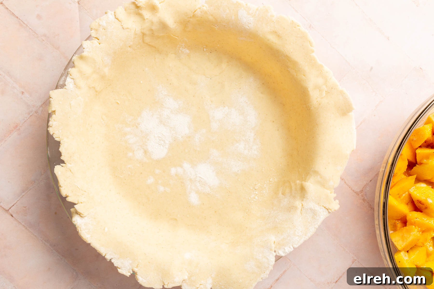 Gluten-Free Peach Mango Pie Recipe 8 Gluten-free pie dough fitted into a 9-inch pie plate with a bowl of peach mango pie filling on the side.