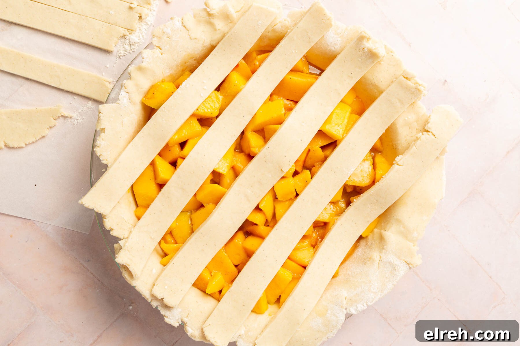 Gluten-Free Peach Mango Pie Recipe 10 Five strips of gluten-free pie dough placed over peach mango pie filling to begin a lattice crust.