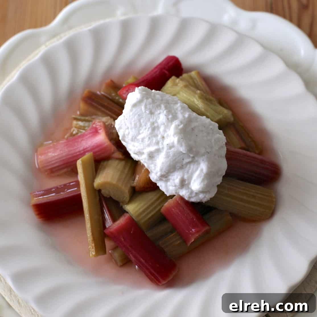 Overhead shot of a white plate topped with poached rhubarb and whipped coconut cream