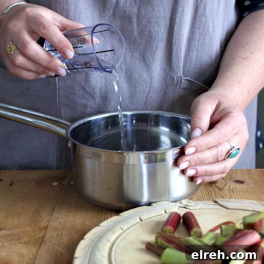 Woman pouring water from a plastic measuring cup into a small silver saucepan