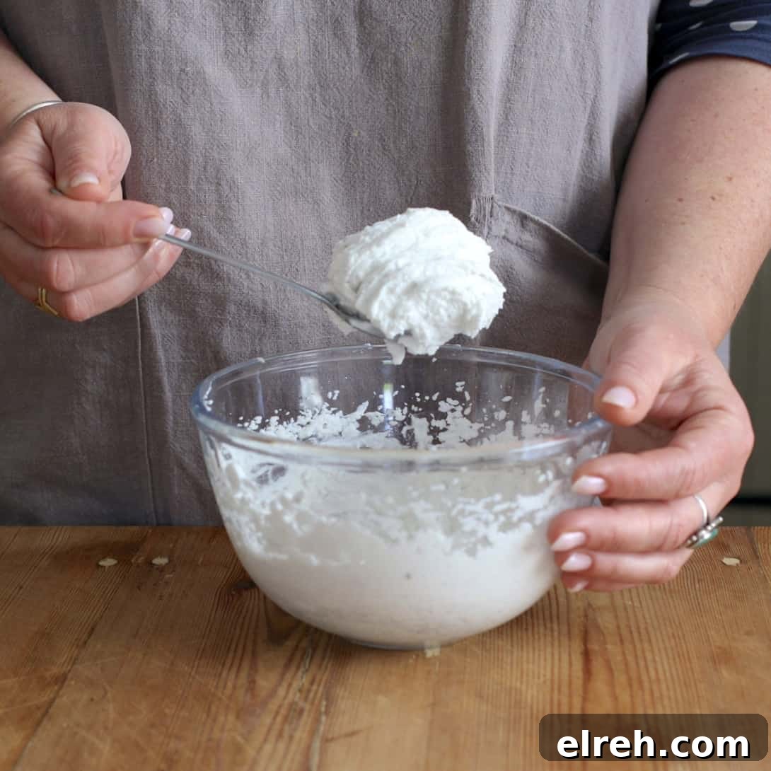 Woman showing how fluffy whipped canned coconut milk can get once beaten