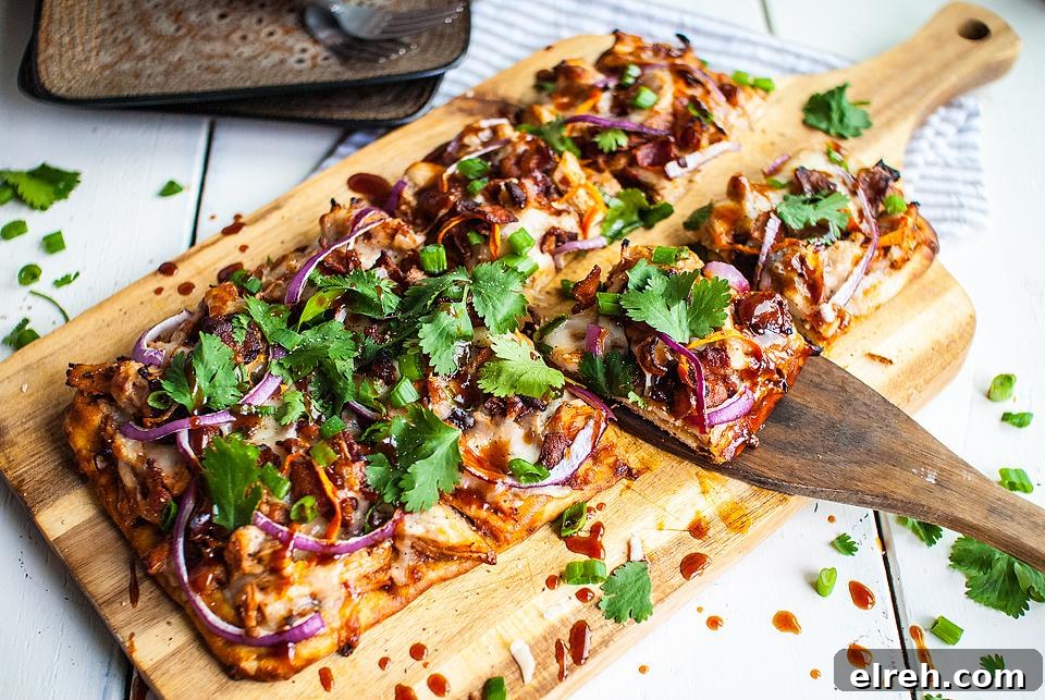 50 July Recipes to Cook This Summer 12 A flatbread pizza on a cutting board with a slice being removed.