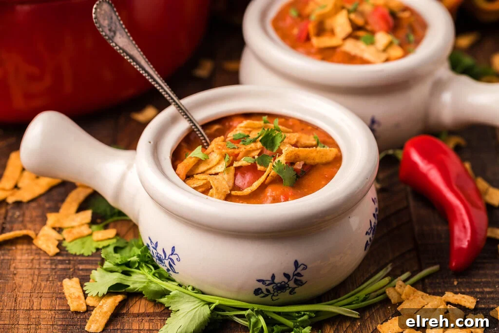 50 July Recipes to Cook This Summer 14 Homemade chicken enchilada soup in a white soup bowl with a handle.