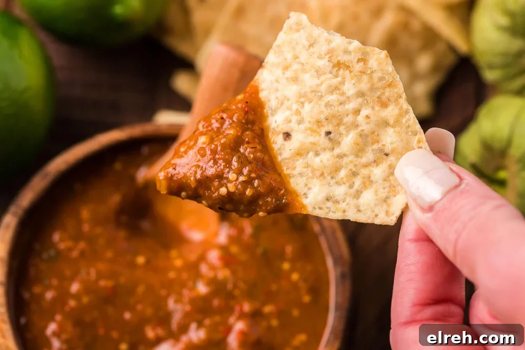 50 July Recipes to Cook This Summer 5 Homemade red salsa in a bowl with a tortilla chip in it.
