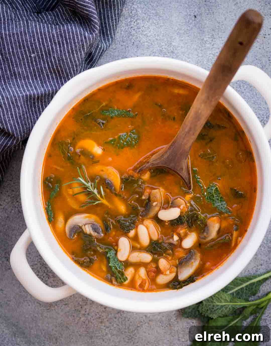 White bean soup with mushroom and kale in tomato-based broth