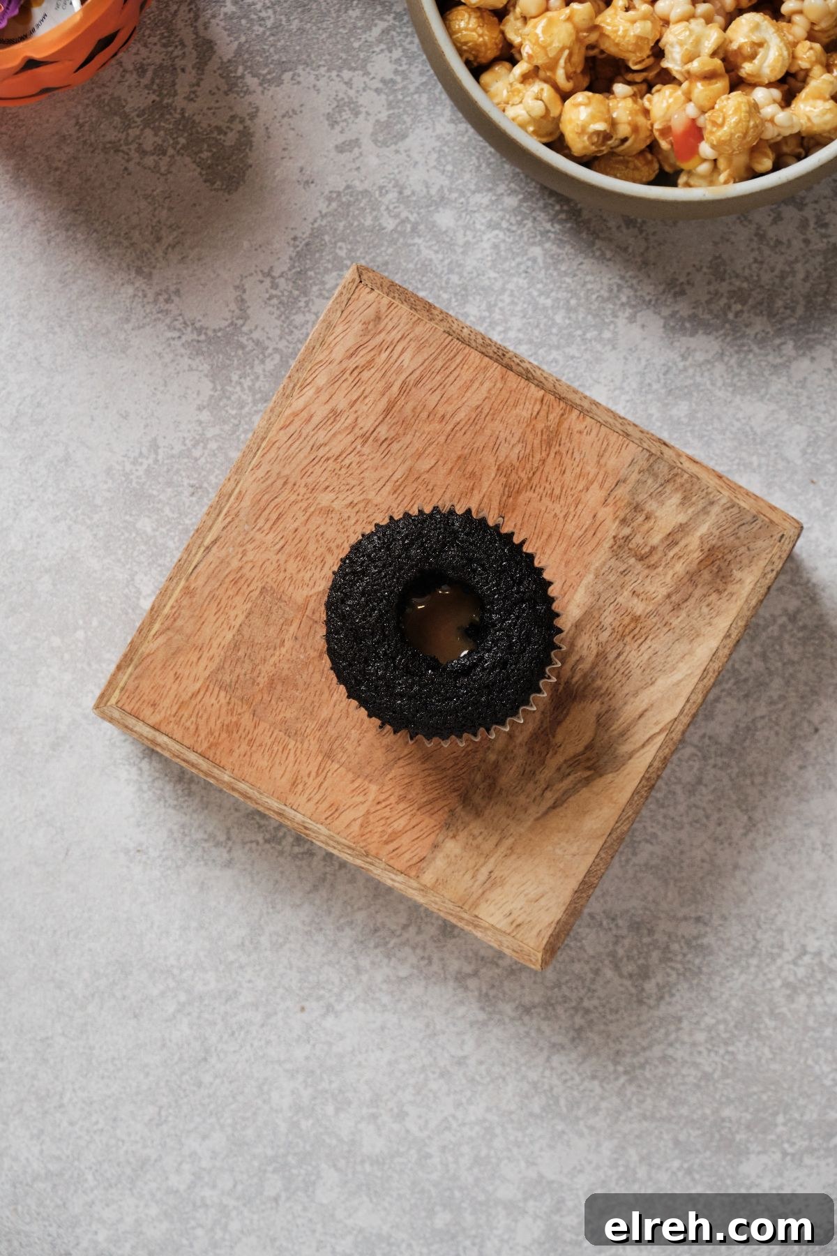 A chocolate cupcake filled with melted caramel in the middle.
