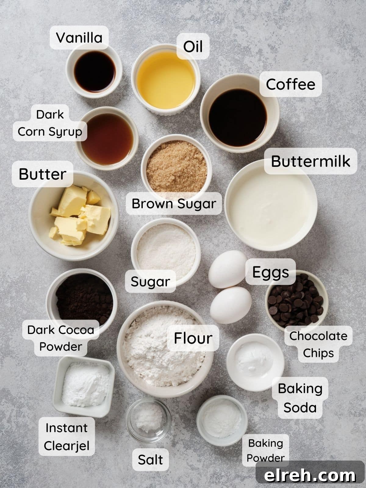 Caramel filled chocolate cupcake ingredients on a table, with the text "flour, sugar, brown sugar, baking powder, baking soda, salt, instant clearjel, dark cocoa powder, butter, eggs, buttermilk, coffee, dark corn syrup, vanilla."