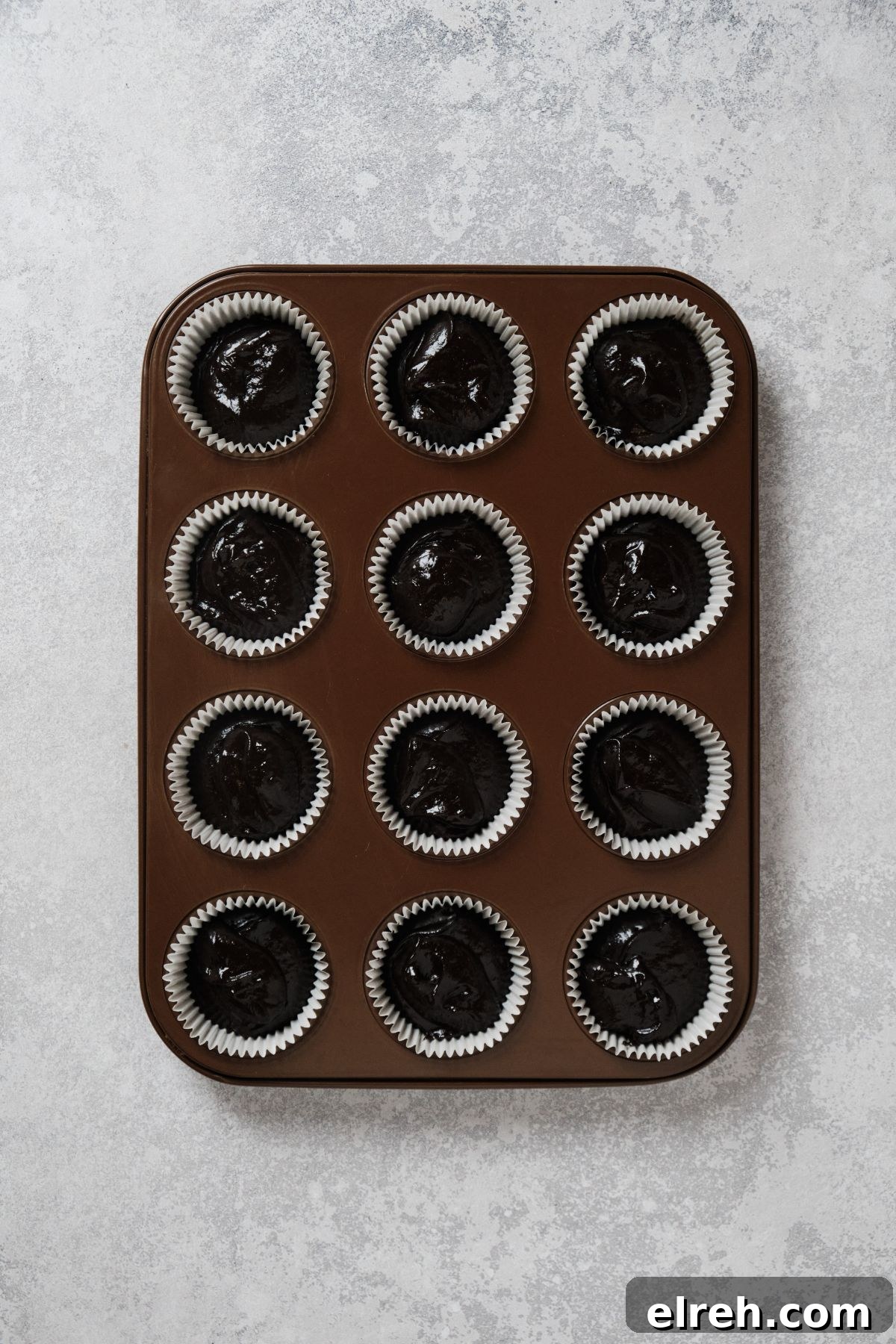 Chocolate cupcake batter in a cupcake tin.